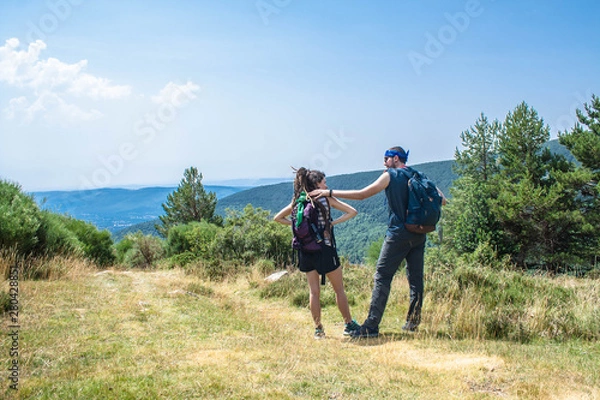 Fototapeta man and woman talk about their route in the mountain