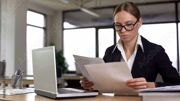 Obraz Businesswoman working with papers, checking annual financial report in office