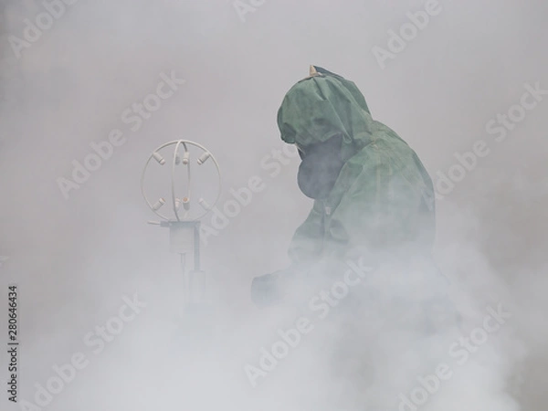 Fototapeta The man in the cost of chemical protection measures the composition of the air