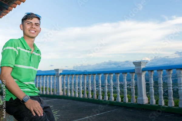 Fototapeta Young guy portrait outdoors with landscape at the background