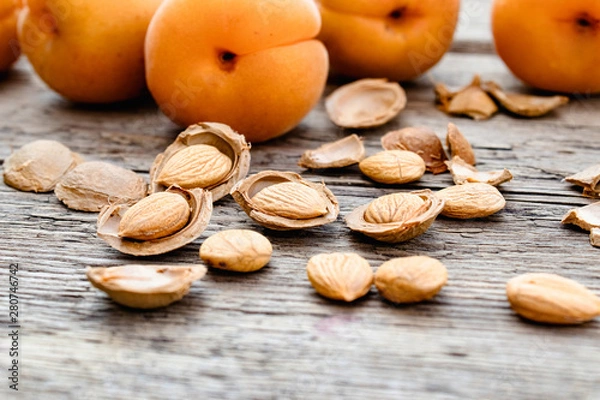 Obraz Apricot and apricot seeds on the background of old boards. Apricot pits for the manufacture of tablets and drugs.