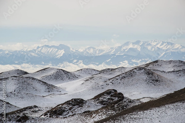 Fototapeta Snowy hills with mountains on the background