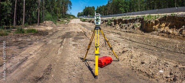 Fototapeta Panoramic view of surveyor equipment (theodolite or total positioning station) on the construction site of the motorway or road