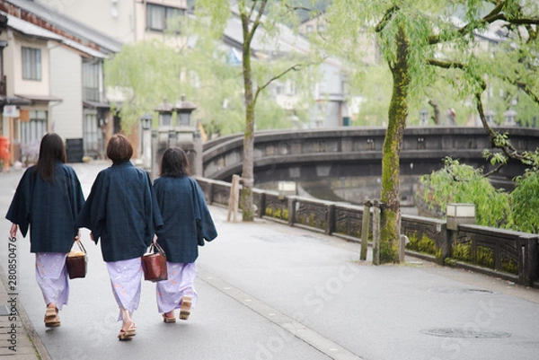 Obraz Japanese woman family wearing kimono and walking at Kinosaki Onsen village street in Toyooka City, Hyogo, Japan. See from back side in morning. Japan traveler trip.