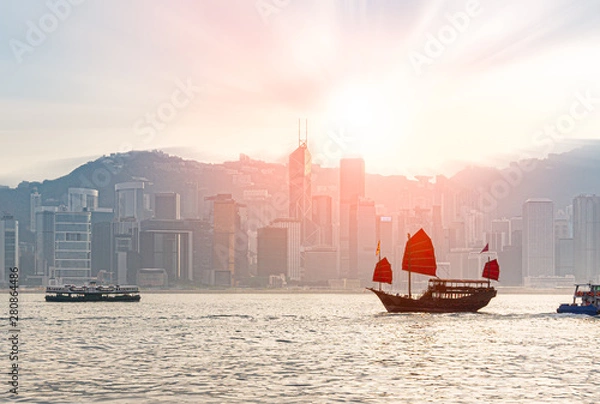 Fototapeta Traditional Chinese junk boat  crossing Victoria Harbor between Kowloon and Hong Kong island