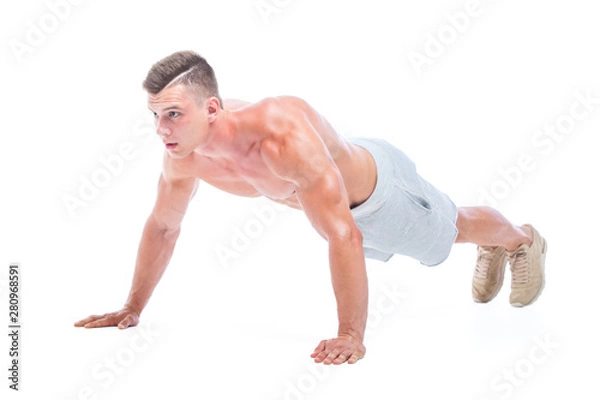 Obraz Sports man doing push ups isolated on a white background. Strong Athletic Man - Fitness Model showing his perfect body.