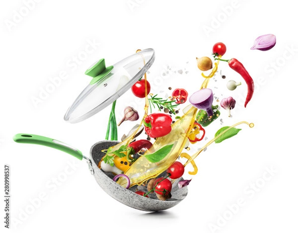 Fototapeta Cooking concept. Vegetables are flying out of the pan isolated on white background. Healthy food.