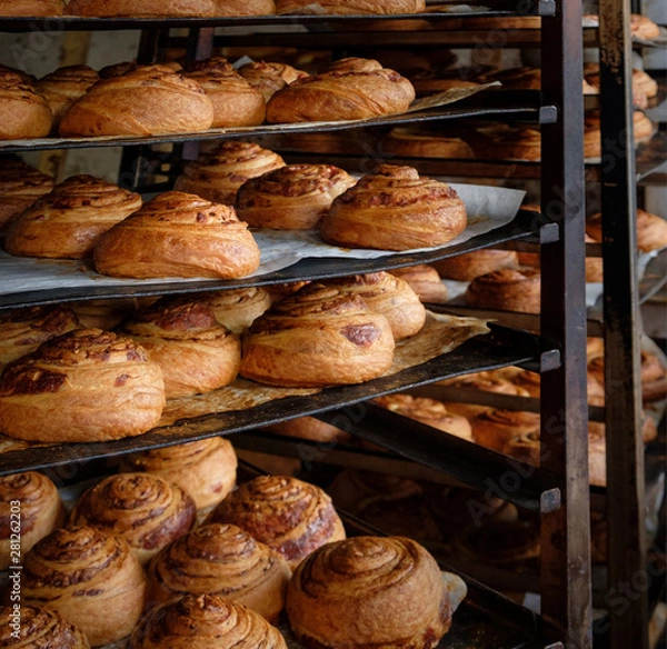 Obraz Making of panettone bread at the local bakery. Fresh puff pastry rolls with ham and cheese on baking pan board. A tray with bakery rolls products.