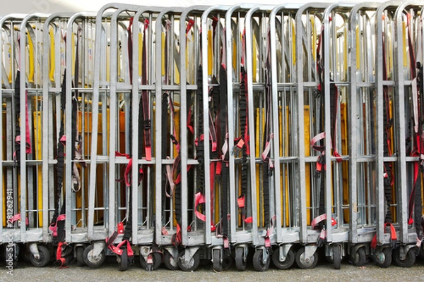 Fototapeta Warehouse trolleys folded and stored in a line with securing straps