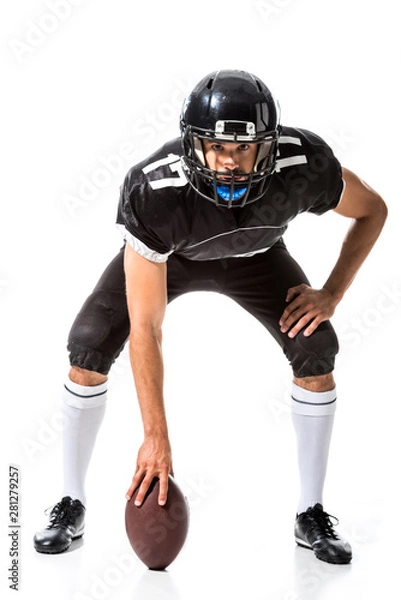 Fototapeta American Football player holding ball and looking at camera Isolated On White