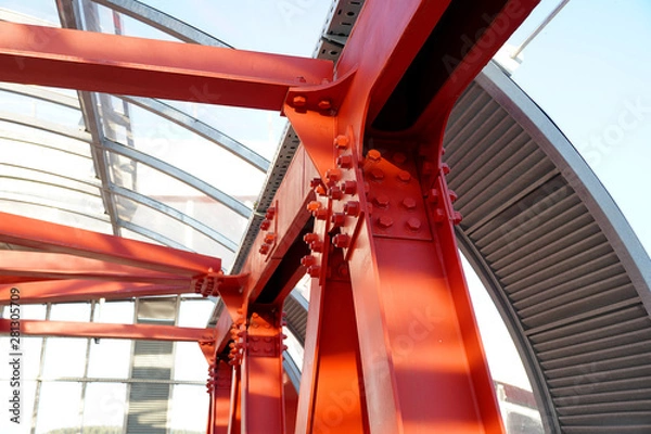 Fototapeta Red iron beams bolted on. Connection of several iron beams in one place.