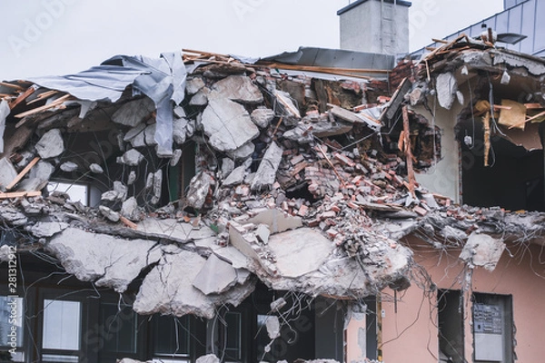 Fototapeta Building been torn down by the demolition team on a spring day