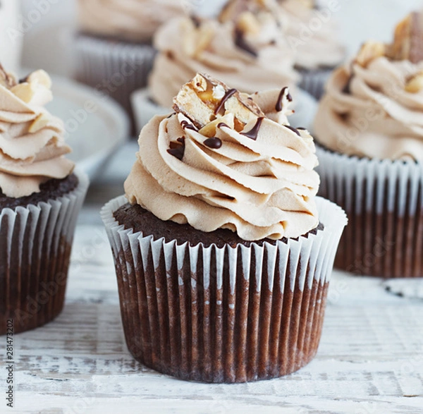 Obraz Chocolate cupcake with mousse cream icing on grunge white wooden background copy space