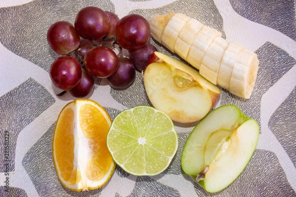 Fototapeta Sliced ​​fruits on a plate on the table. top view.