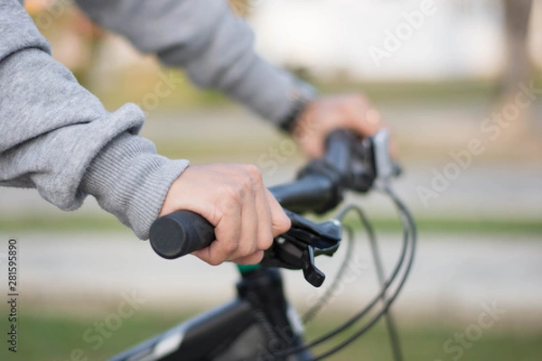 Fototapeta close up shot of hijab  woman's hand was holding the wheel of a bicycle in a park