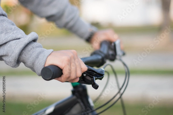 Fototapeta close up shot of hijab  woman's hand was holding the wheel of a bicycle in a park