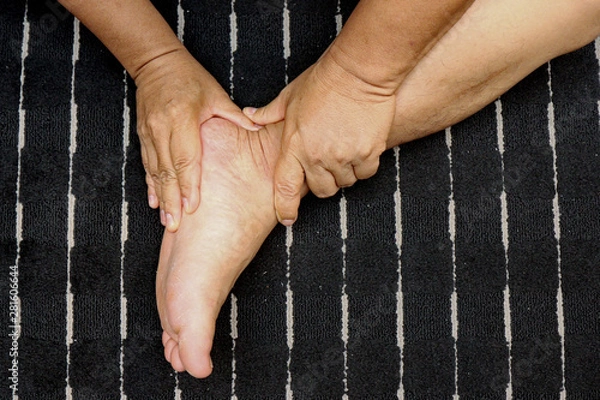 Obraz Treating injuries to the feet and leg with the push of a finger according to tricks of  traditional Thai massage .