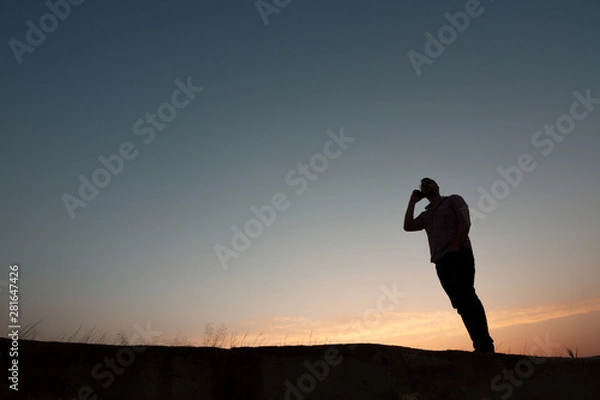Obraz silhouette of man with cell phone at sunset