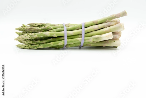 Fototapeta Asparagus surrounded by a medical tape on weighing scale for diets