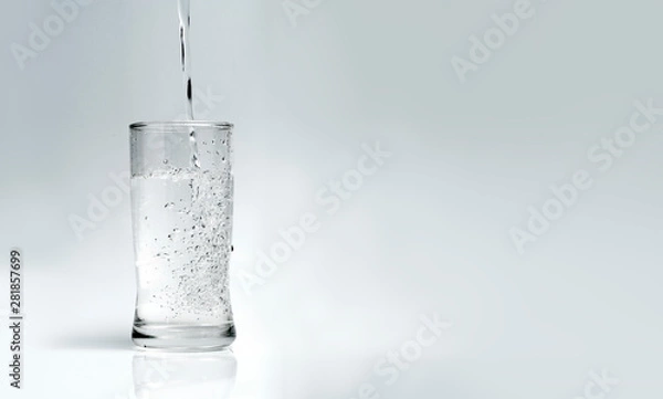 Obraz pour water into the glass on a white background