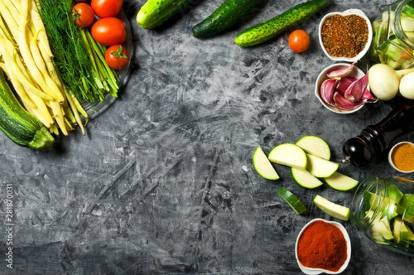 Obraz Vegetables on the background. Fresh vegetables (cucumbers, tomatoes, onions, garlic, dill, green beans) on a gray background. Top view. Copy space