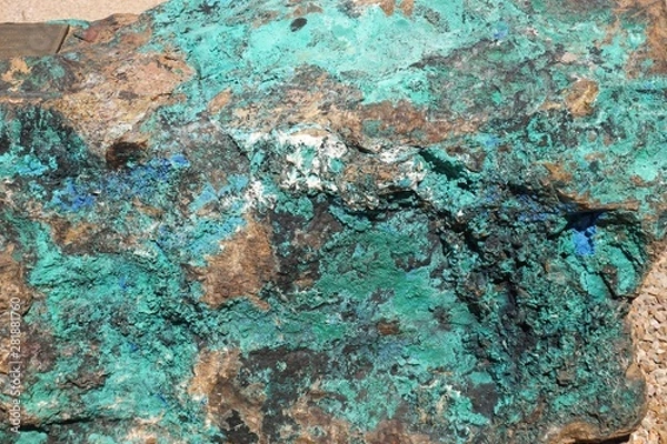 Fototapeta Closeup macro view of natural rock surface with brown, green and blue mineral inclusions