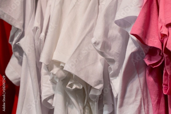 Fototapeta Things on storefront. Shop with new clothes. Suits hang on hangers.