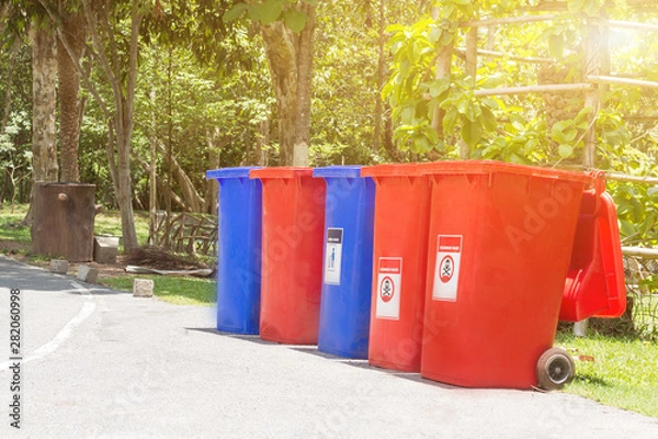 Fototapeta Garbage bins for recycling with recycle colors symbol in the park,Environmental pollution issues.