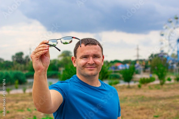 Obraz A young man with a smile suggests wearing glasses in order to improve your vision.