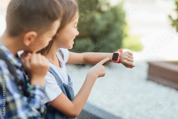 Fototapeta Learning new technology. Close up photo, child plkay with smartwatch.