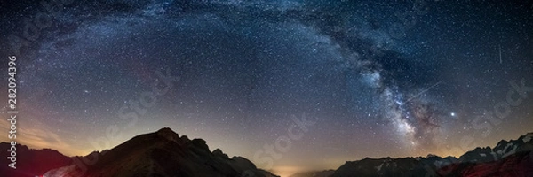 Fototapeta Droga Mleczna wygina się gwiaździste niebo w Alpach, Massif des Ecrins, ośrodek narciarski Briancon Serre Chevalier, Francja. Panoramiczny widok na wysokie góry i lodowce, fotografia astro, obserwacja gwiazd