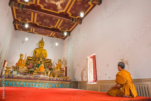 Obraz Monk pays respect to Buddha statues at Wat Yai Chom Prasat - Samut Sakhon, Thailand