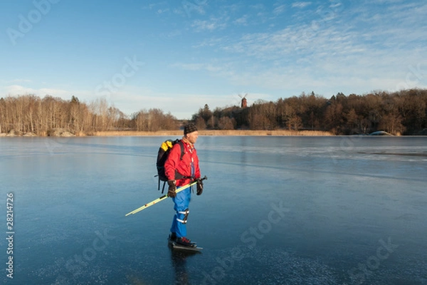 Fototapeta A male ice skater on a frozen lake