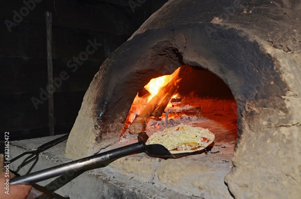Fototapeta Pizza on  spatula ready to go into oven   