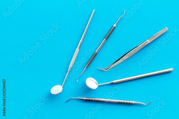Obraz Dentist tools for cure teeth on blue background top view