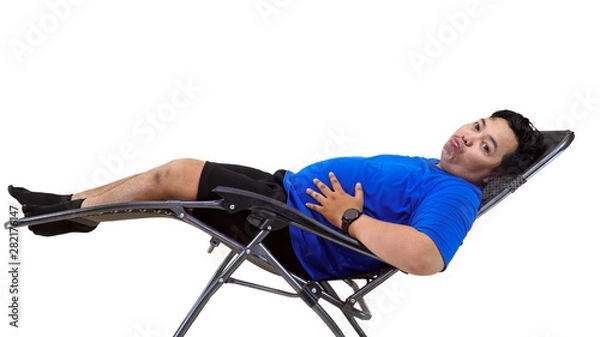 Fototapeta Portrait of fat obese and overweight man sit and laying on lazy couch holding his tummy thingking about his weight problem