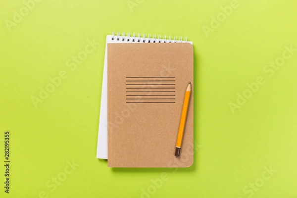Fototapeta school notebook on a green background, spiral notepad on a table.