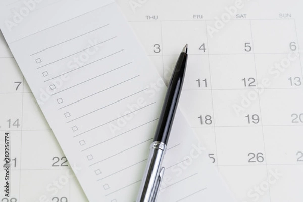 Fototapeta Pen on checklist with checkbox notepad on clean calendar using as special event, planner, important reminder or appointment list concept