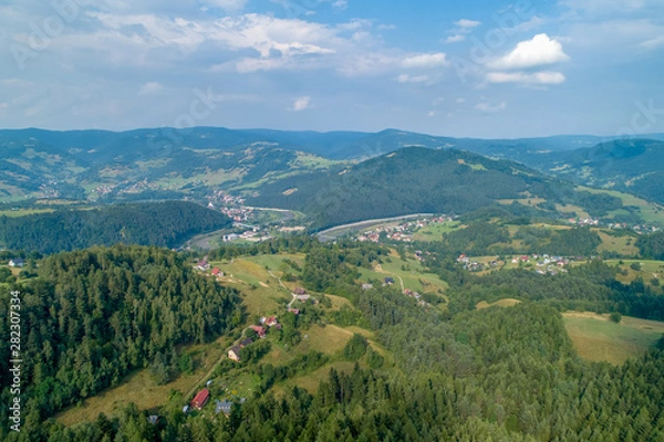 Fototapeta Sunset in the mountains. Forests and white clouds in the sky_1