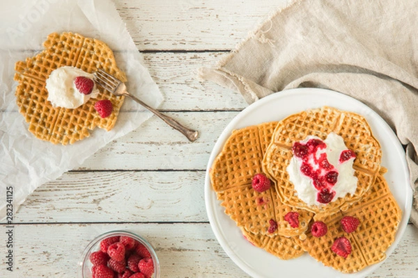 Fototapeta Waffles with raspberries and cream seen from above