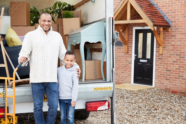 Obraz Portrait Of Father And Son Unloading Furniture From Removal Truck Into New Home
