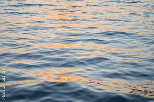 Fototapeta Sparkling water surface on sunset.  Nature background concept. - Image