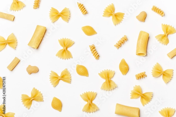 Obraz Various uncooked pasta on white background. Top view. Raw pasta with ingredients for cooking. Food concept
