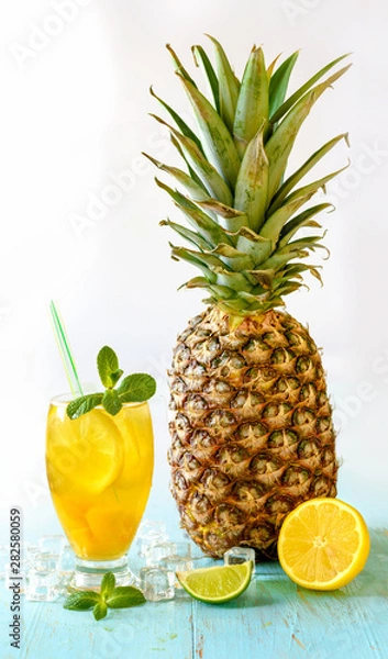 Fototapeta Yellow iced tea with lemon, pineapple