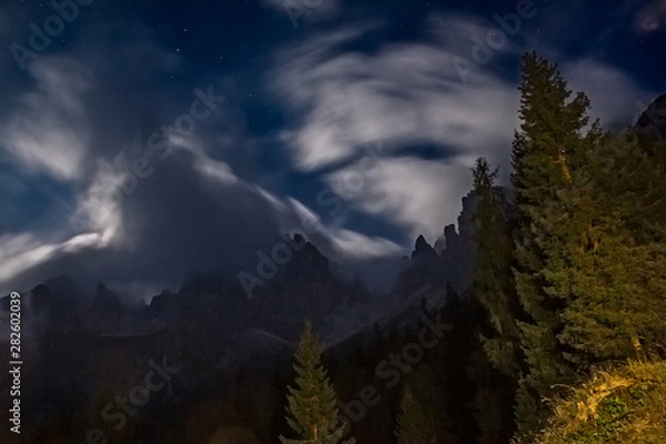 Obraz Night view with the moonlight among the clouds on the peaks of the Friulian Dolomites, near the Rifugio Giaff, in Friuli, Italy.