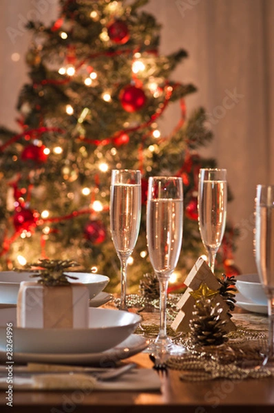 Fototapeta A decorated christmas dining table with champagne glasses