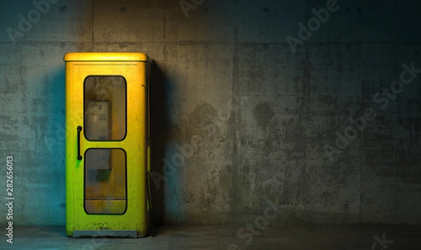 Obraz Single old yellow phone booth in retro style standing on the floor in front of the concrete wall at night time. Gloomy poorly lit interior in loft style with copy space. 3D rendering