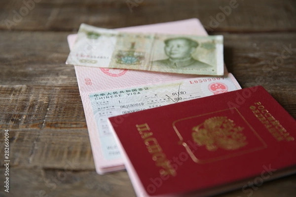 Fototapeta A Russian passport with a Chinese visa and money is one yuan. Visa stamp, passport. Vacation and travel concept.