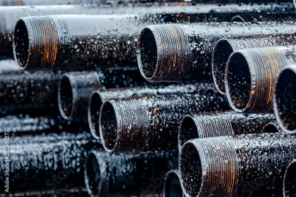 Fototapeta Oil Drill pipe. Rusty drill pipes were drilled in the well section. Downhole drilling rig. Laying the pipe on the deck. View of the shell of drill pipes laid in courtyard of the oil and gas warehouse