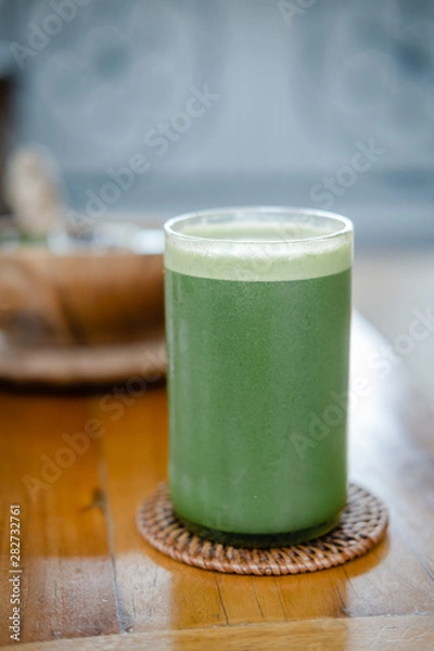 Fototapeta Glass of green celery juice on wooden table